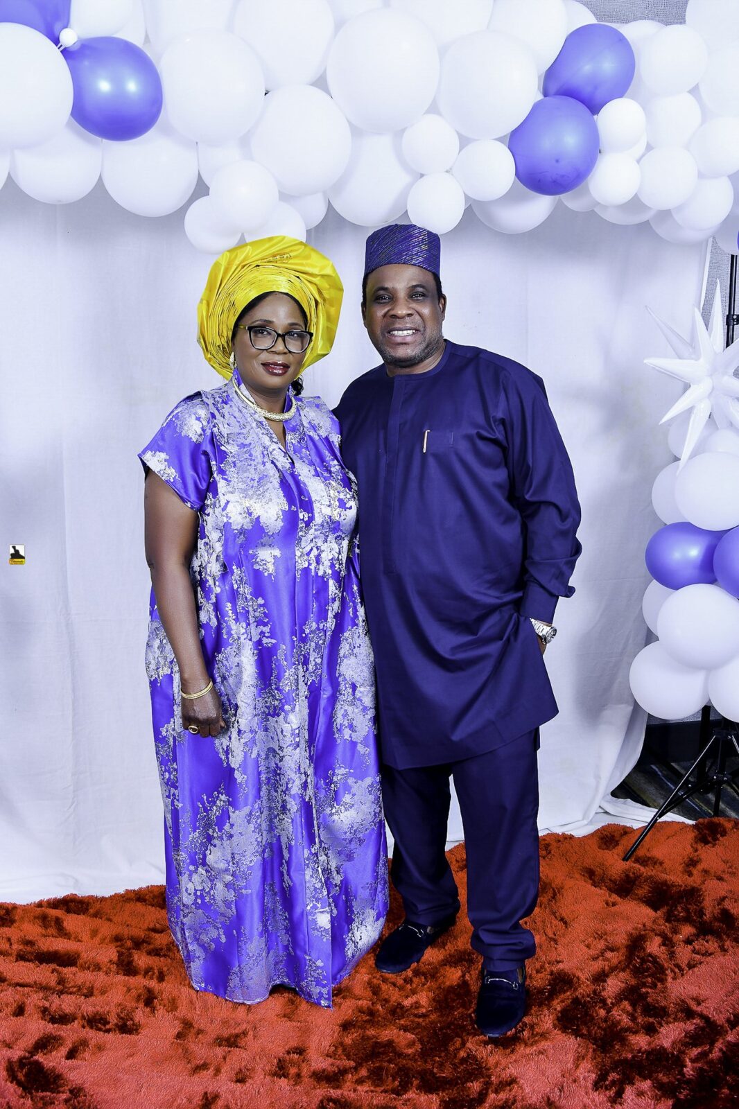 Man in blue and woman in a blue patterned outfit with a yellow headwrap