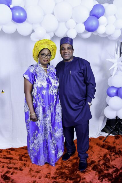 Man in blue and woman in a blue patterned outfit with a yellow headwrap