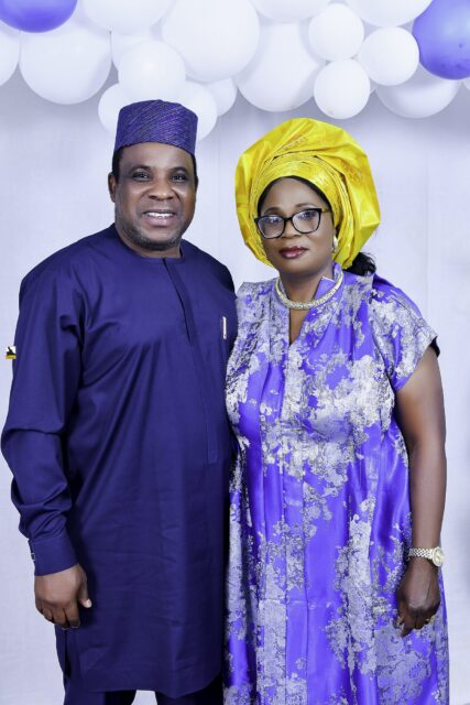 Man in blue and woman in a blue patterned outfit with a yellow headwrap