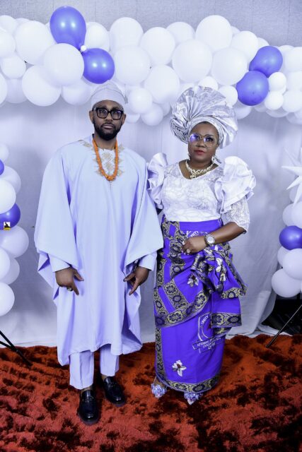 Man in pale blue and woman in white and blue posing together