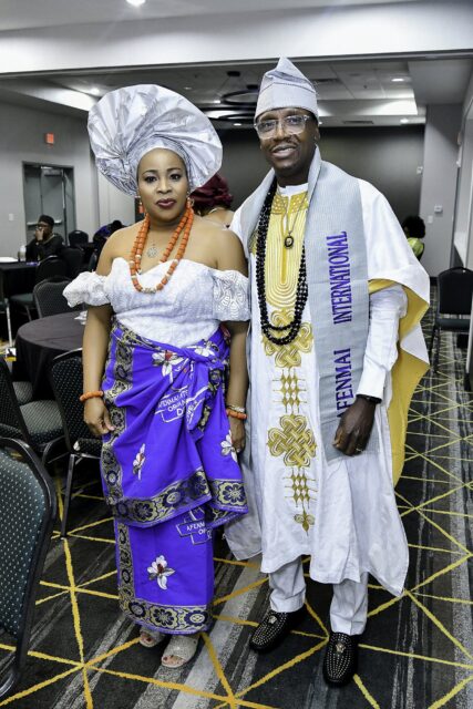 Two attendees in white and blue clothing standing in the convention room