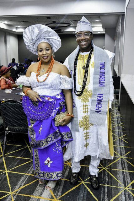 Two attendees in white and blue clothing standing in the convention room