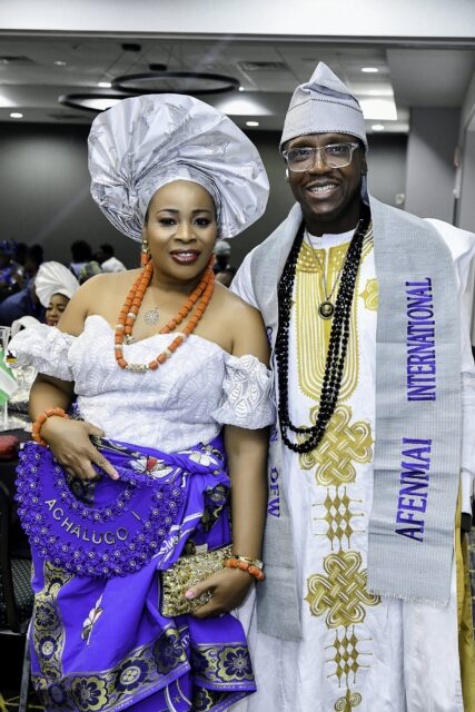 Two attendees in white and blue clothing standing in the convention room