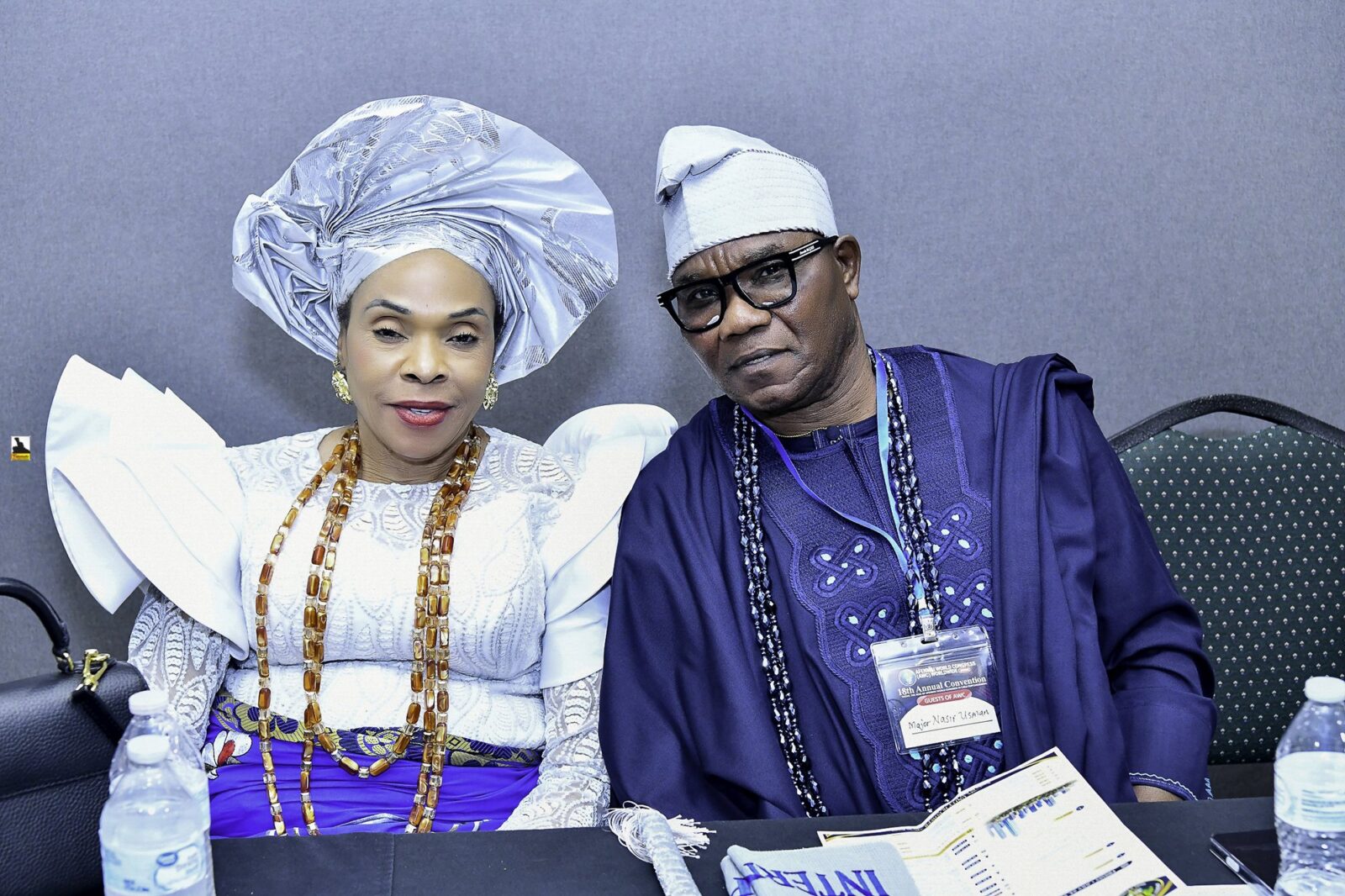 Two attendees in blue and white clothing seated side by side