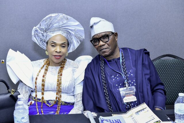Two attendees in blue and white clothing seated side by side