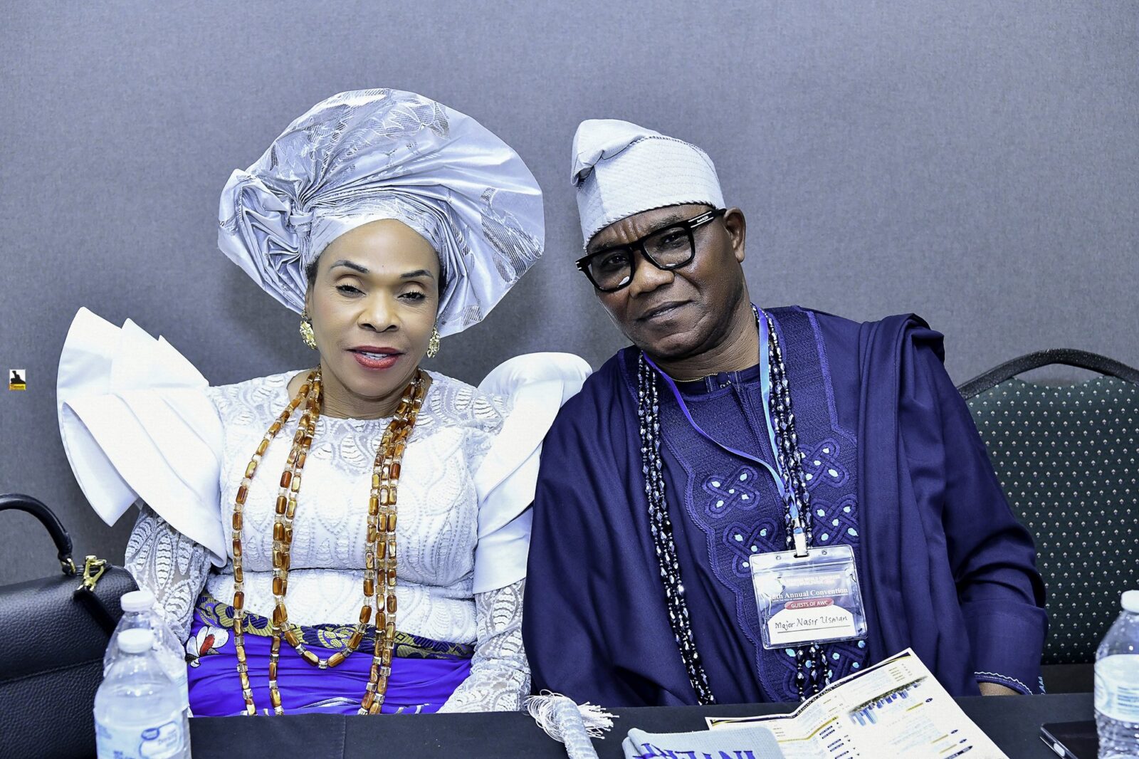 Two attendees in blue and white clothing seated side by side