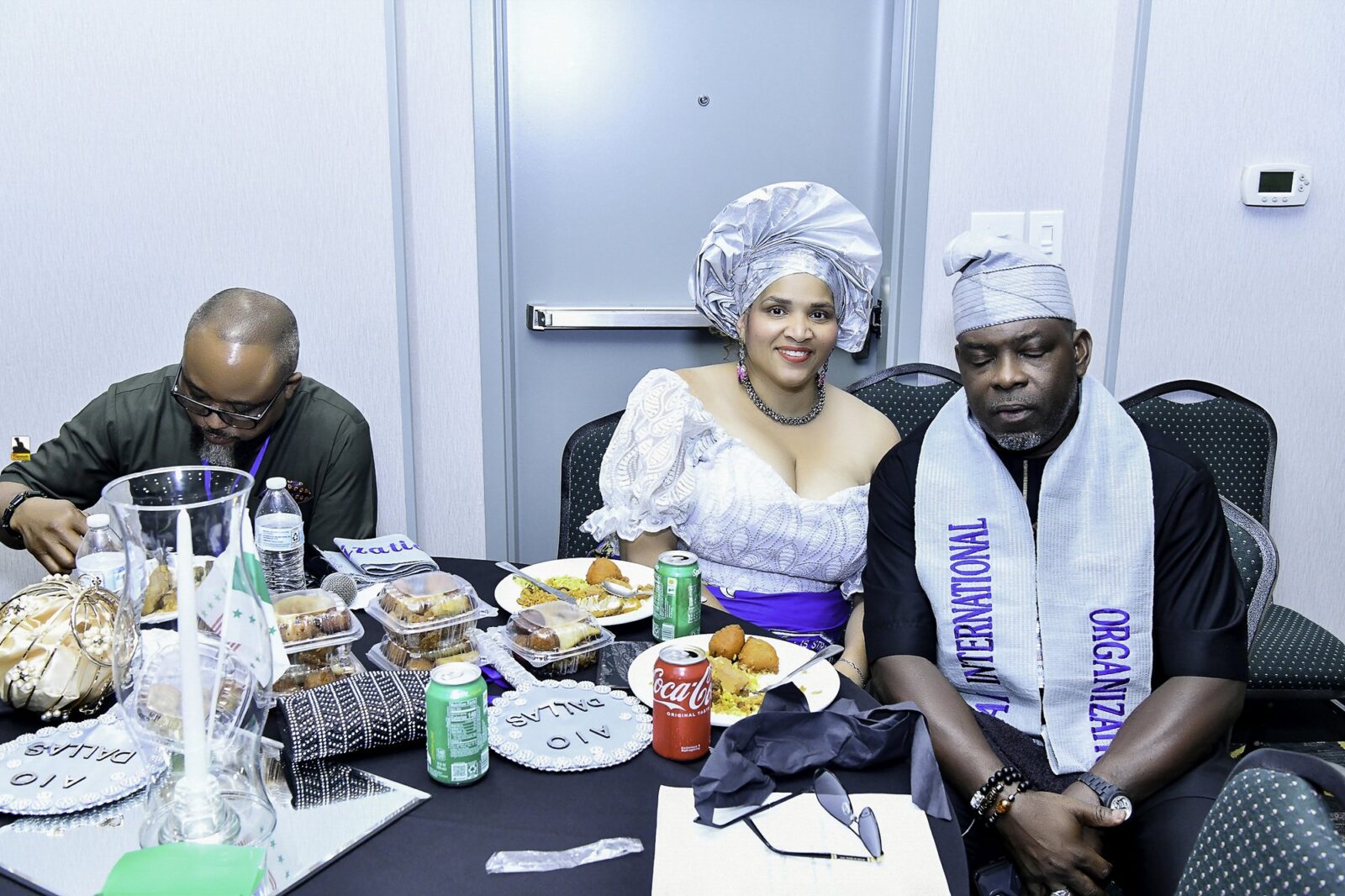 Attendees in white and blue clothing seated at a dining table