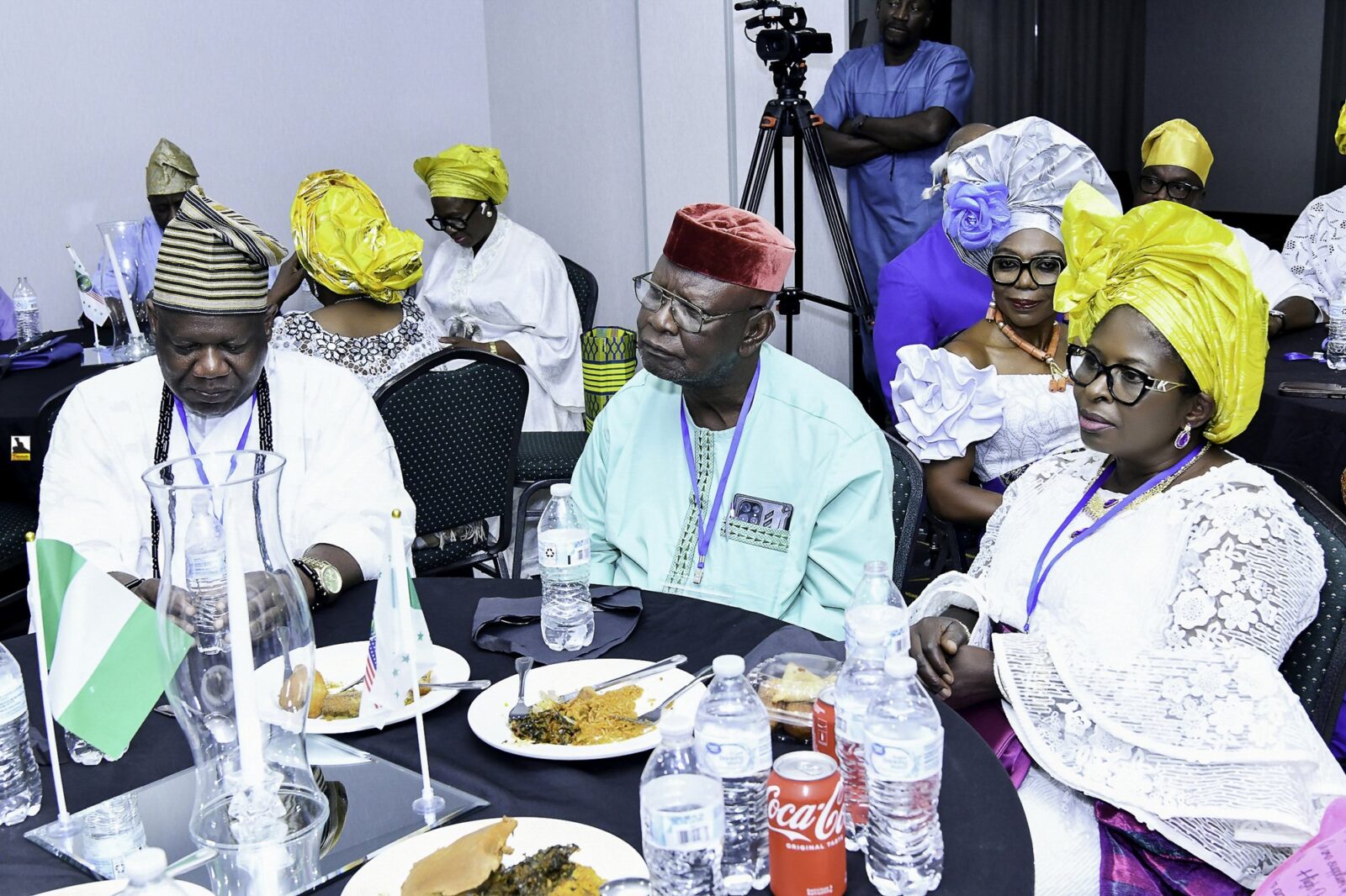 Three attendees with patterned caps and a yellow headwrap at a table