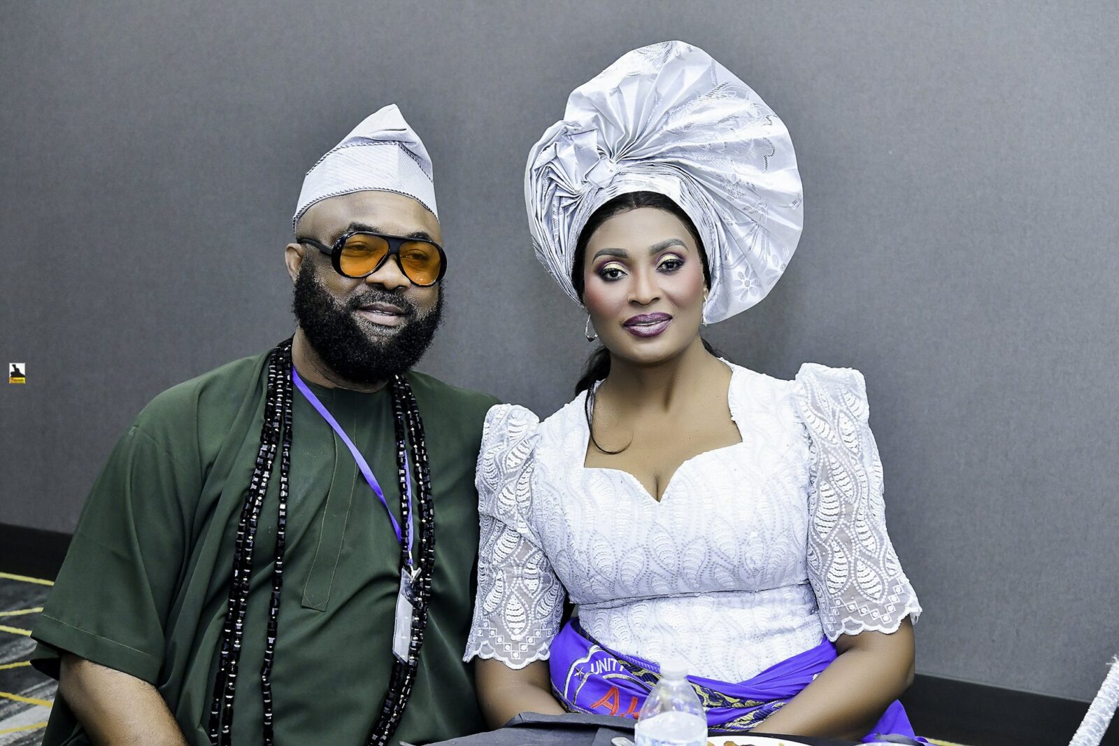 Man in dark green and woman in white and blue seated together
