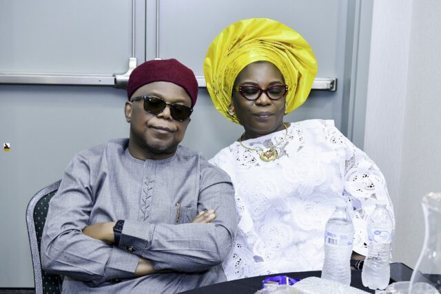 Man in gray clothing and woman in white with a yellow headwrap