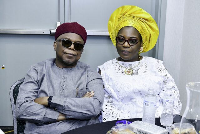 Man in gray clothing and woman in white with a yellow headwrap