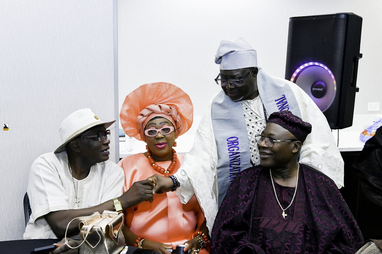 Attendees gathered around a table, including a woman in orange