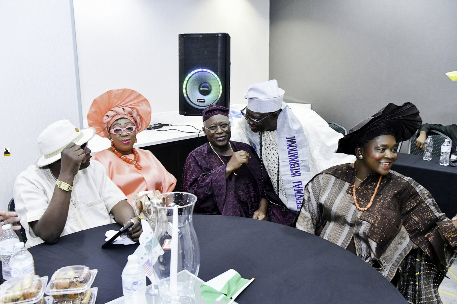 Attendees gathered around a table, including a woman in orange