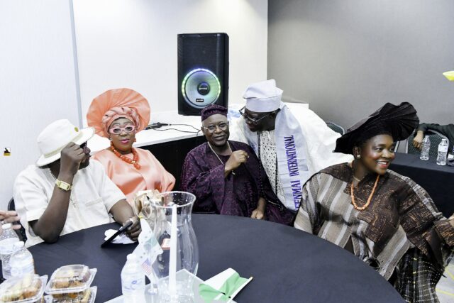 Attendees gathered around a table, including a woman in orange
