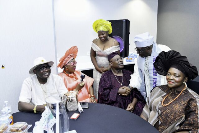 Attendees gathered around a table, including a woman in orange